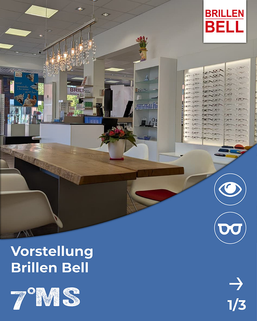 Ein moderner Augenoptikladen mit einer langen Holztheke und weißen Stühlen. Im Hintergrund sind Gläser in einer Vitrine ausgestellt. Eine Blumenarrangement steht auf der Theke. Links ist ein Plakat mit Informationen über die Angebote des Geschäfts zu sehen.